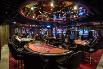 A close-up shot of golden coins falling around a spinning roulette wheel, representing immersive casino action at SPINARA.